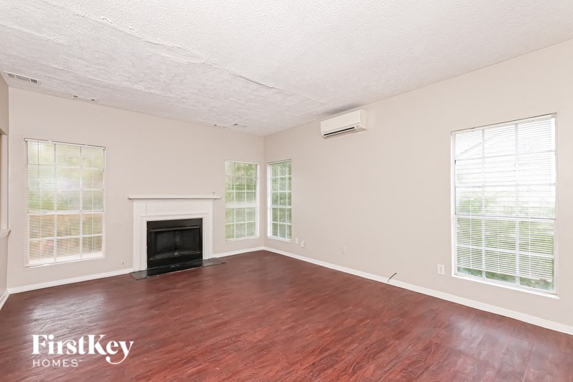 a living room with wood floors and a fireplace