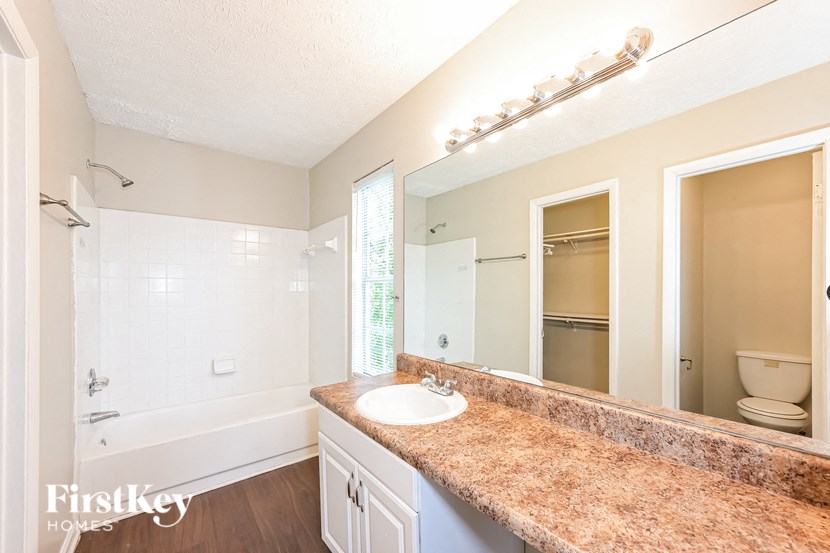 a bathroom with a sink and a shower and a mirror