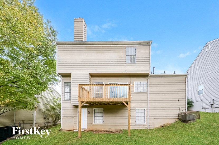 the back of a house with a deck and a tree