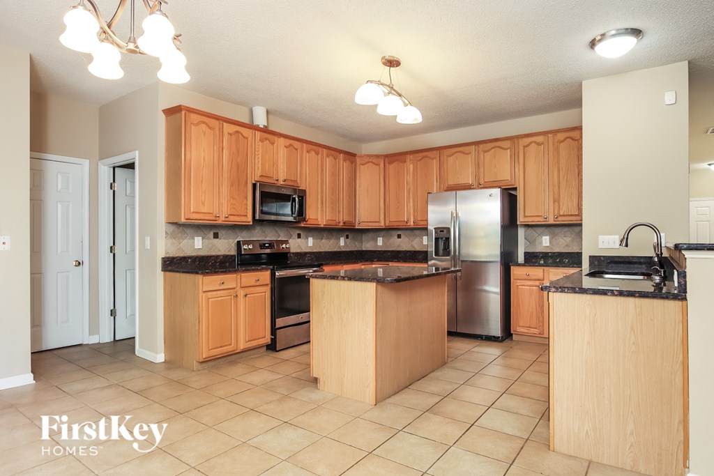 A kitchen with wooden cabinets and a stainless steel refrigerator.