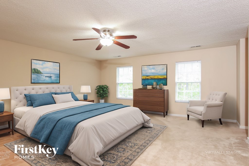 A bedroom with a bed, dresser, and chair.