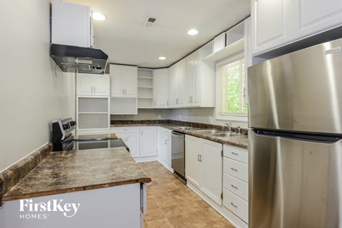 a white kitchen with stainless steel appliances and white cabinets