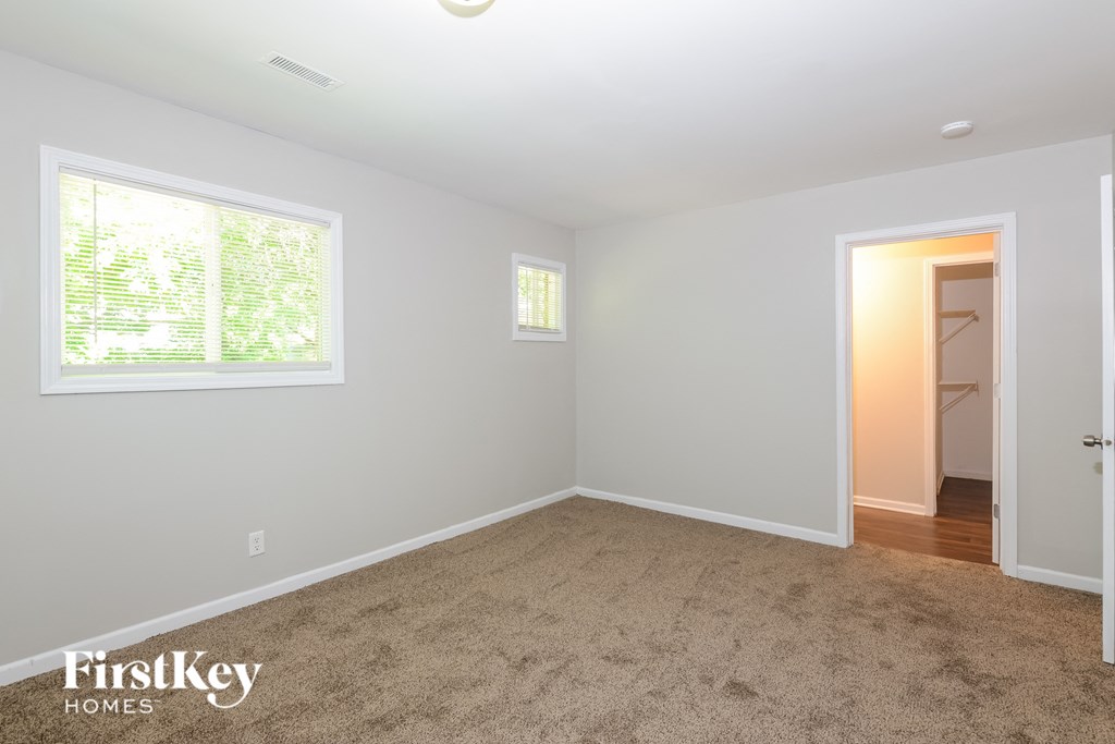 a empty room with carpet and a window