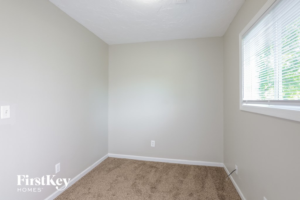 a bedroom with a carpeted floor and a large window