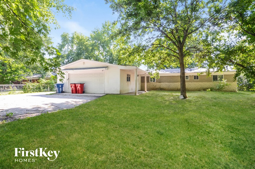 a white house with a yard and a tree