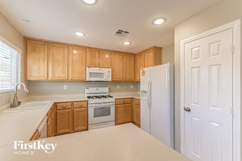 A kitchen with wooden cabinets and white appliances.