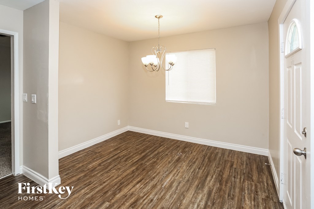 A room with wooden flooring and a chandelier.