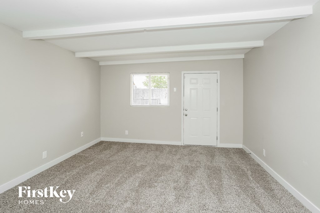 A room with a carpeted floor and a window letting in natural light.