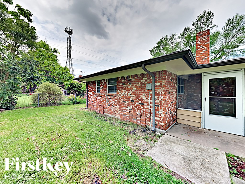 a small brick house with a yard and a white door