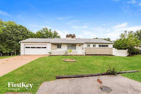 A house with a white picket fence is for sale.