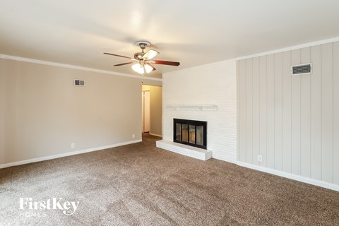 A room with a fireplace and a ceiling fan.