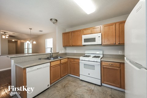 A kitchen with wooden cabinets and white appliances.