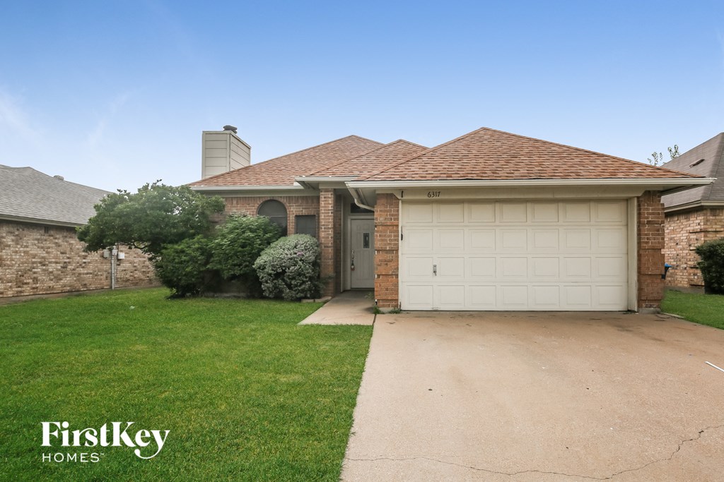 a house with a white garage door and a lawn