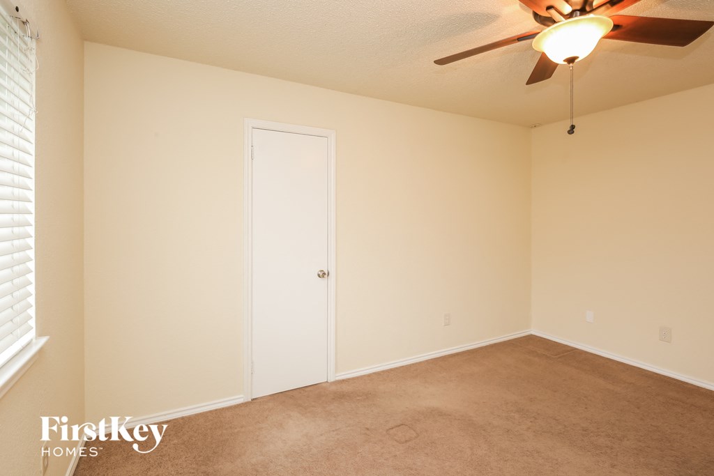 a bedroom with a ceiling fan and a closet