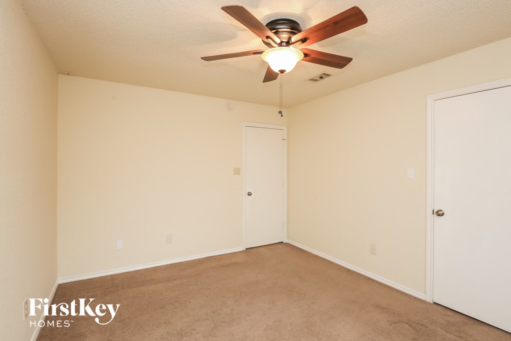 a bedroom with carpet and a ceiling fan