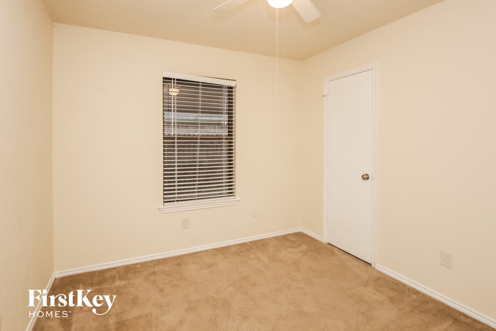 a bedroom with a window and a white door