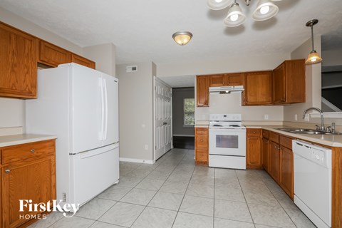 A kitchen with white appliances and wooden cabinets.