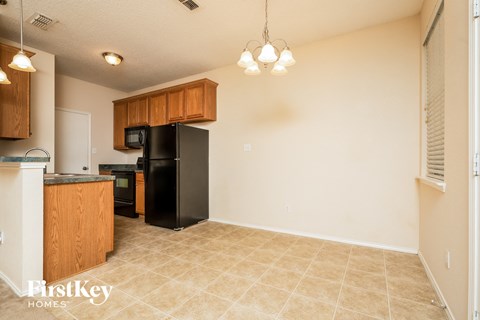 A kitchen area with a black fridge and microwave.