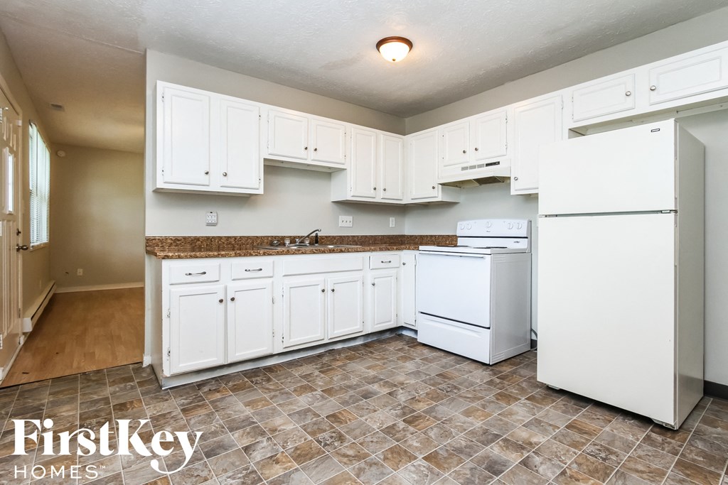 A kitchen with white appliances and cabinets.