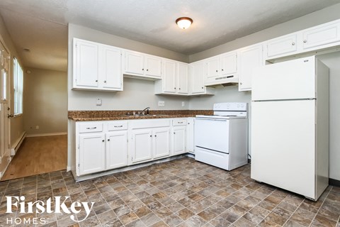A kitchen with white appliances and cabinets.