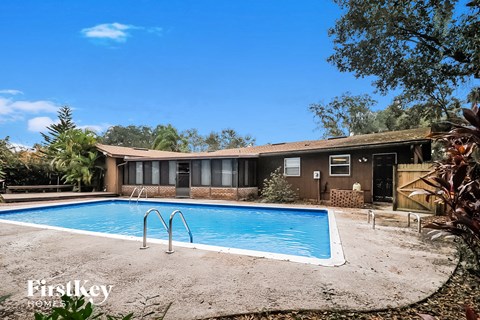 A swimming pool in a backyard with a house in the background.