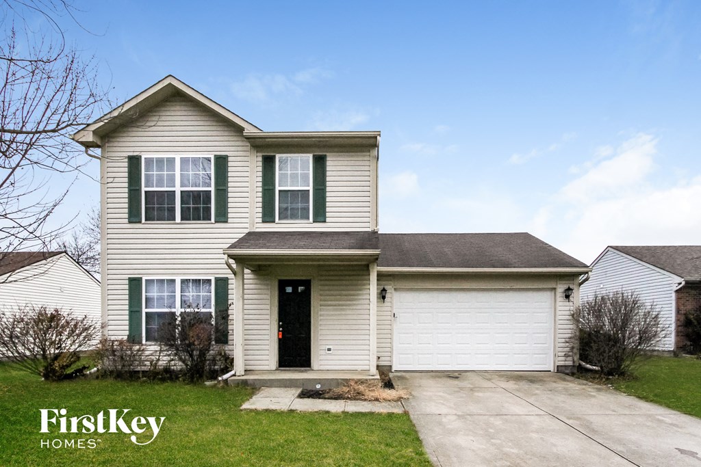 A two-story house with a garage is for sale.