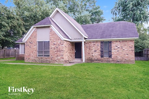 A brick house with a black door and windows.