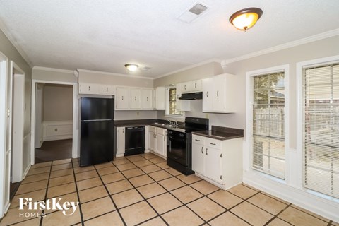 A kitchen with black appliances and white cabinets.