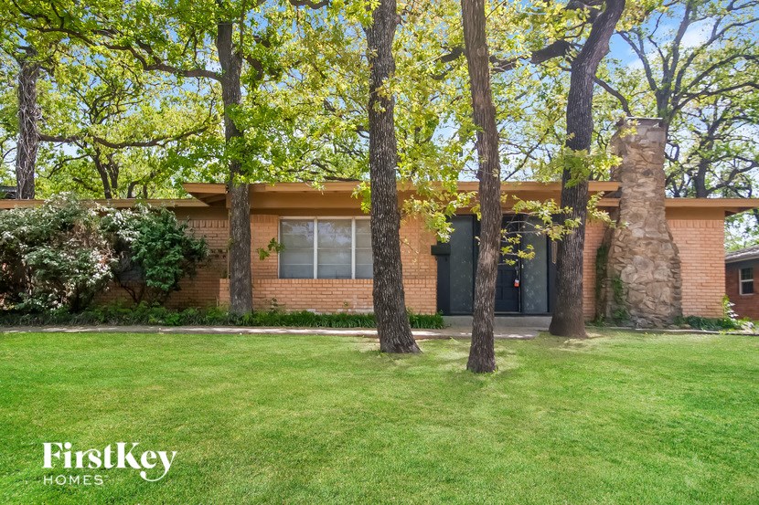 a small brick house with trees in front of it