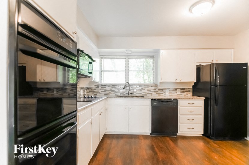 a renovated kitchen with black appliances and white cabinets