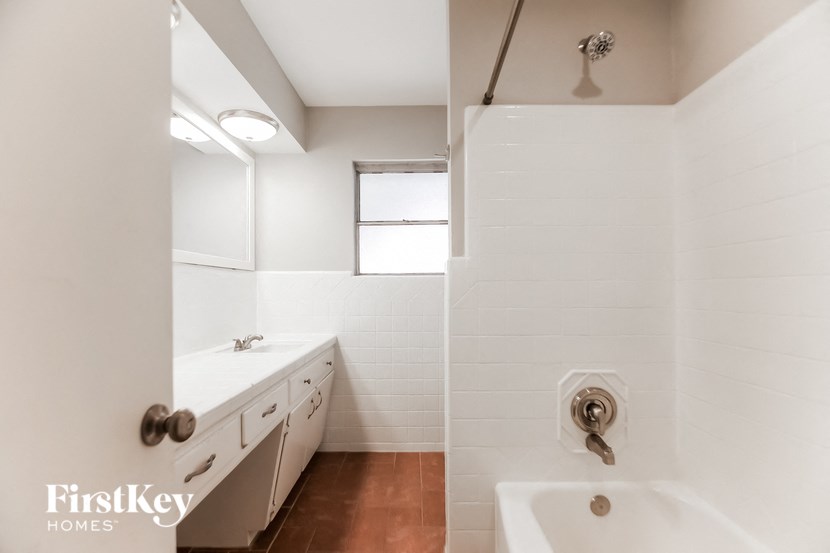 two views of a white bathroom with a tub and a sink and a shower