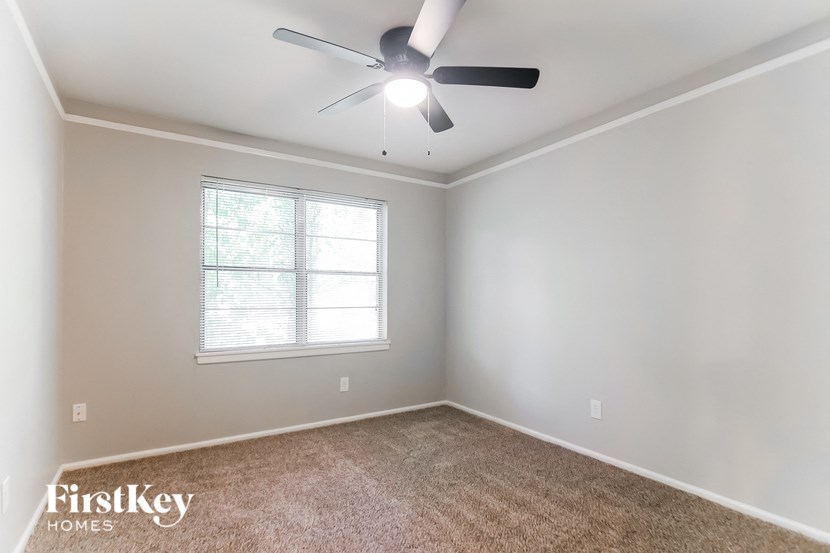 an empty room with a ceiling fan and a window