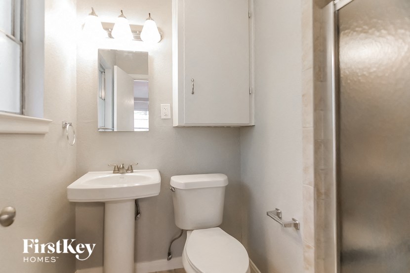a bathroom with a sink toilet and a mirror and a shower