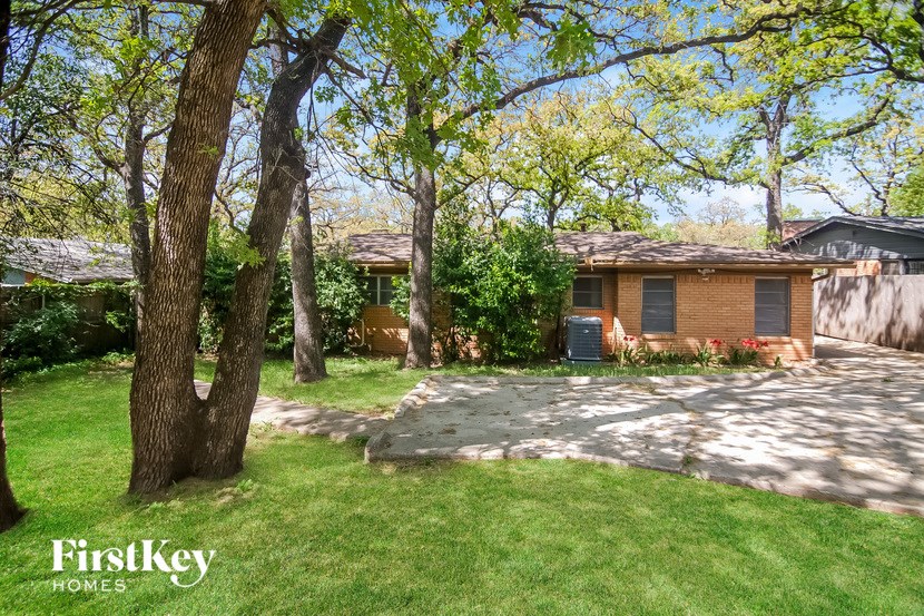 a house with a yard and trees and a driveway