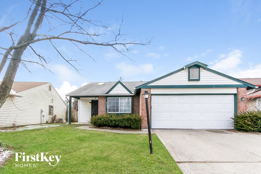a white garage door in front of a brick house