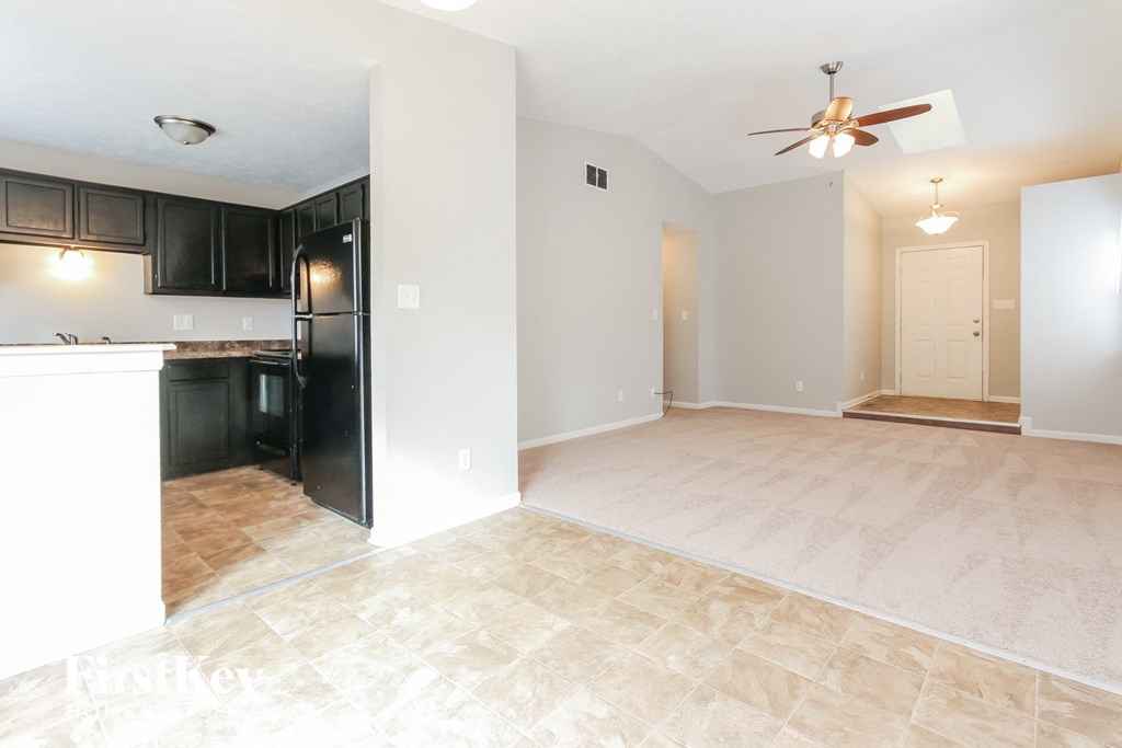 an empty kitchen and living room with a ceiling fan