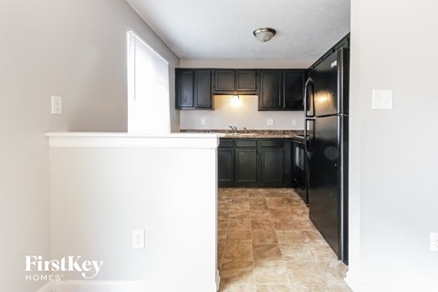 a kitchen with black cabinets and a black refrigerator