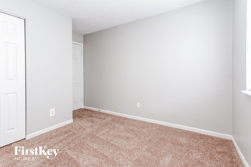 a bedroom with a carpeted floor and white walls