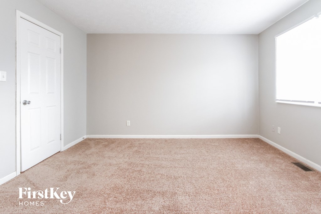 a bedroom with a carpeted floor and a white door