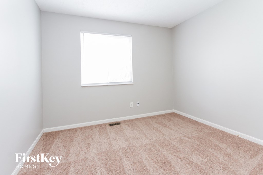 a empty room with a window and a carpeted floor