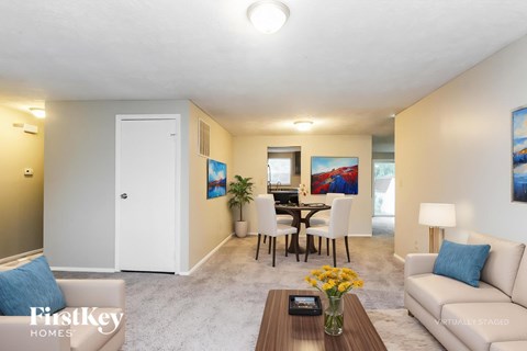 A living room with a couch, a coffee table, and a painting on the wall.