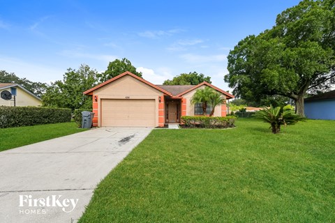 a single story home with a garage and a green lawn