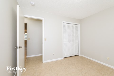 a bedroom with a closet and a door to the bathroom