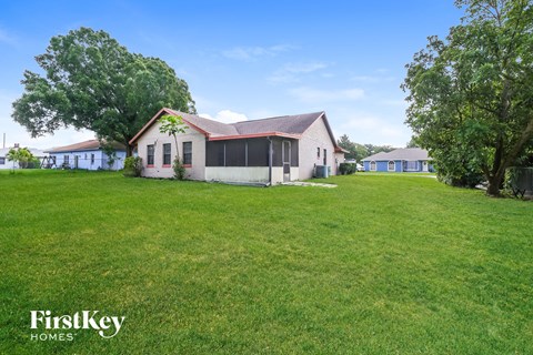 a white house with a large yard and some trees