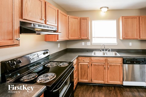 A kitchen with wooden cabinets and a black stove top oven.
