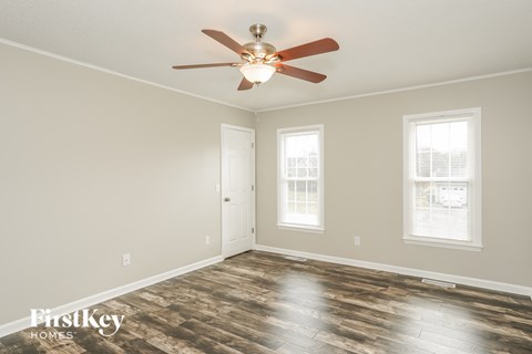 a living room with a ceiling fan and a door