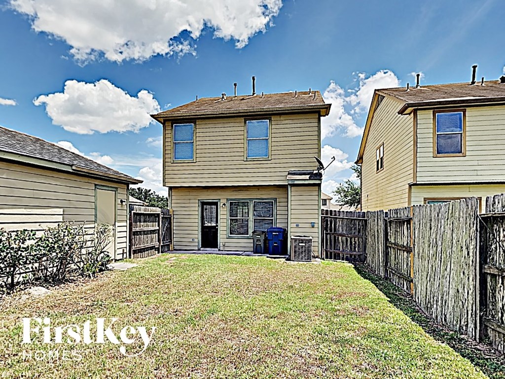 the backyard of a house with a yard and a fence