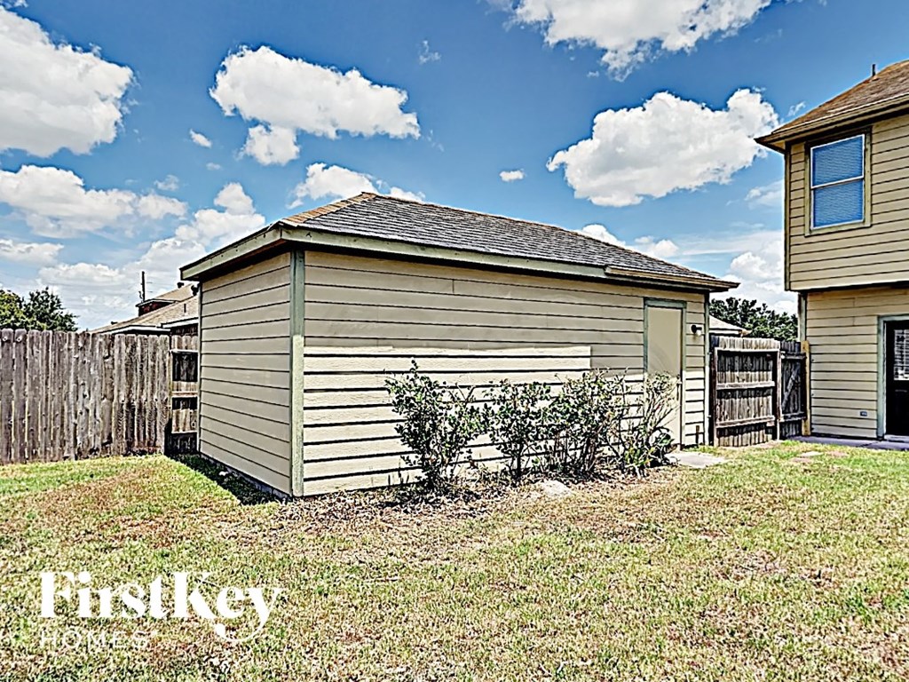 a backyard with a fence and a small house