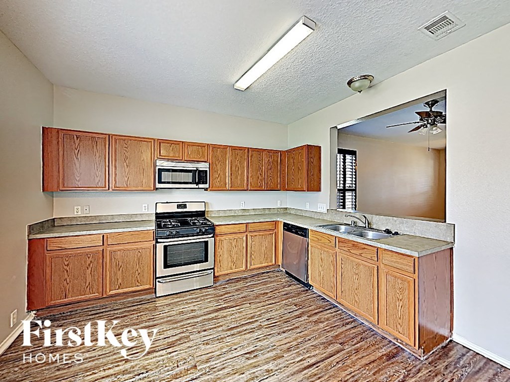 a kitchen with wooden cabinets and a stove and a sink