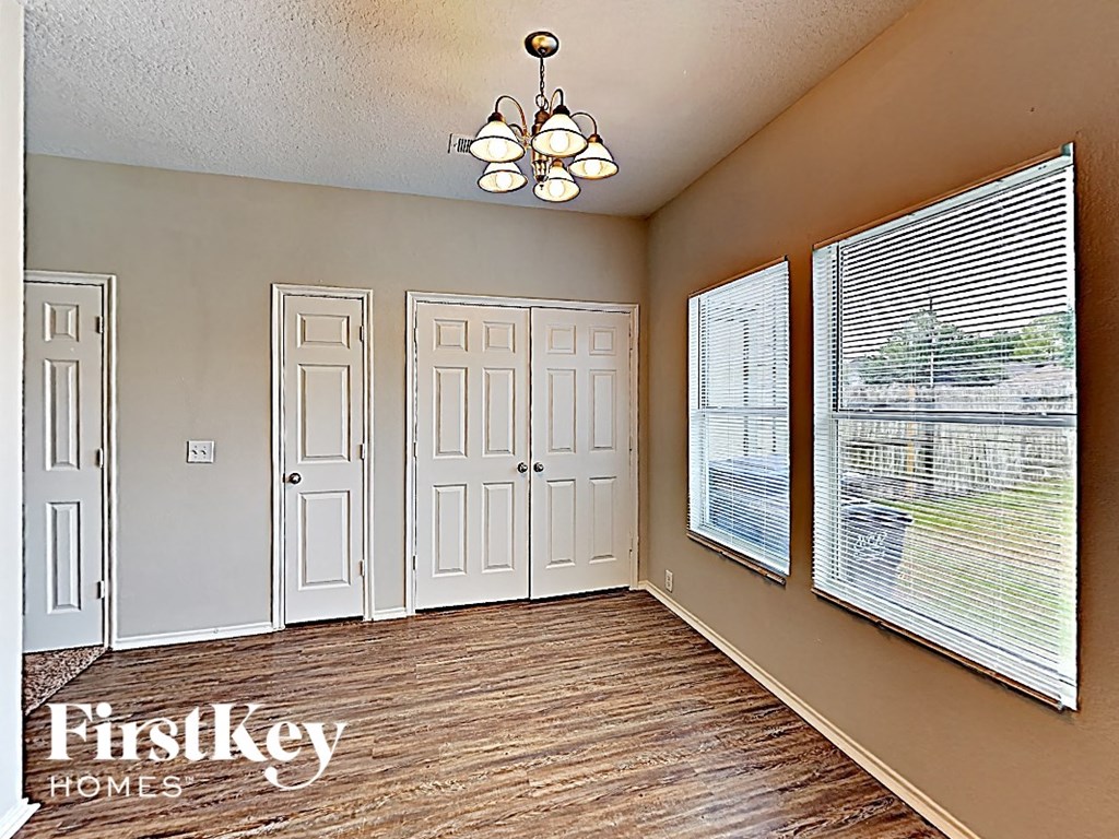 an empty living room with a large window and a door